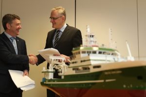 Marine Institute CEO Dr Peter Heffernan and Skipsteknisk CEO Hans Ove Holmøy shake on signing the contract for the new research vessel’s design package in front of a model of Celtic Explorer. Image: Skipsteknisk - @ Fiskerforum